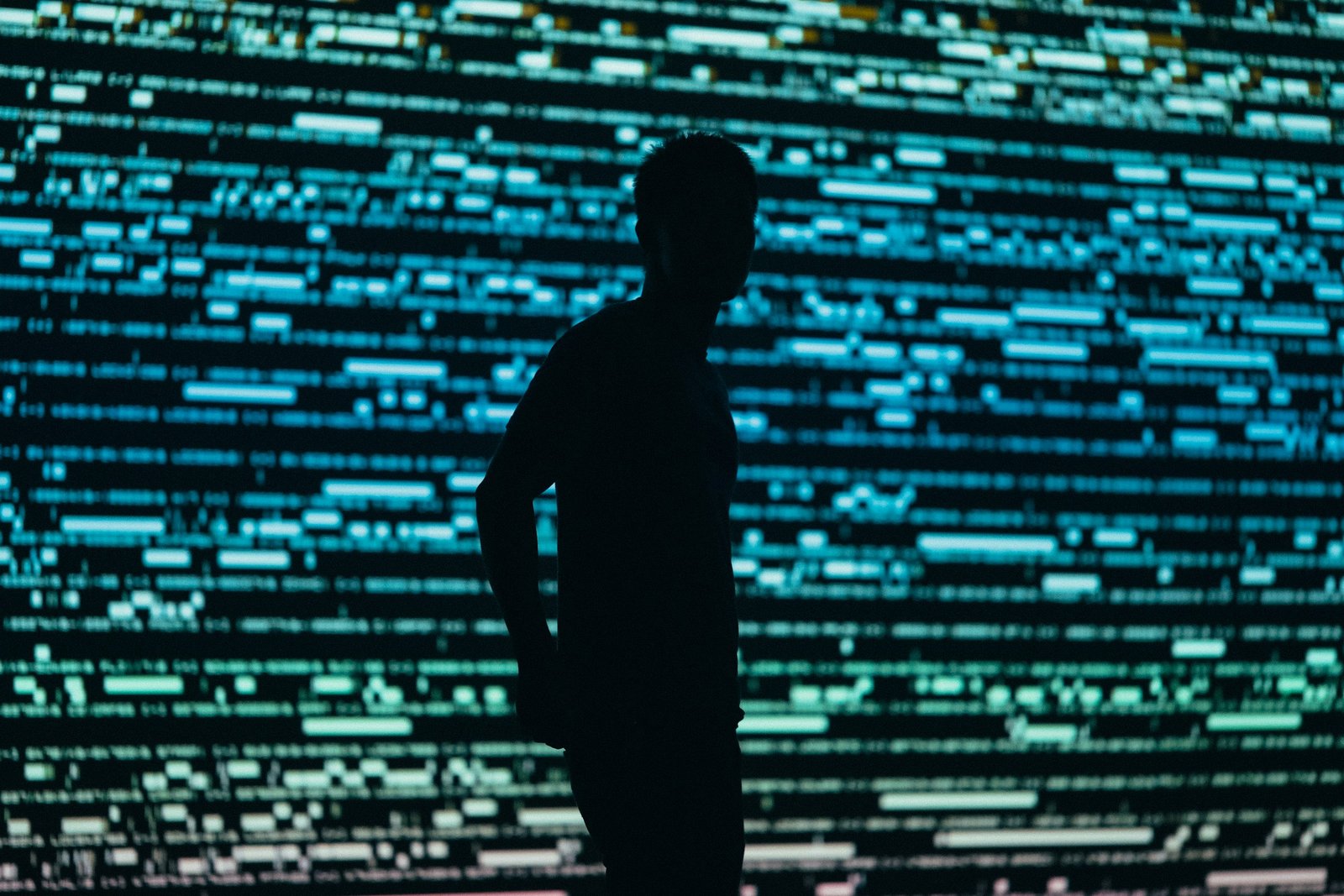 Silhouette of a person surrounded by lights, metaphor of the surveillance and social control allowed by the AI. Photo by Chris Yang on Unsplash.