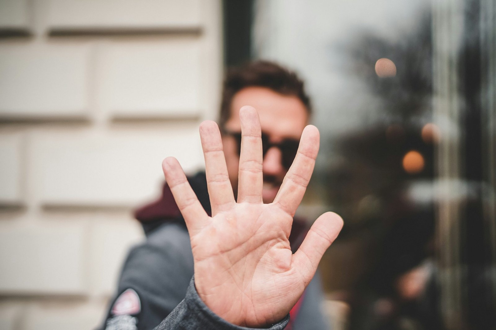 Homme levant la main. Photo de Zan Lazarevic sur Unsplash.